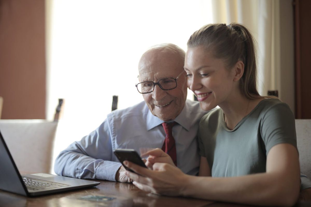 An instructor helping an older adult use a smartphone with confidence
